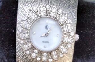 JL women’s silver-tone crystal-encrusted quartz bangle cuff watch.